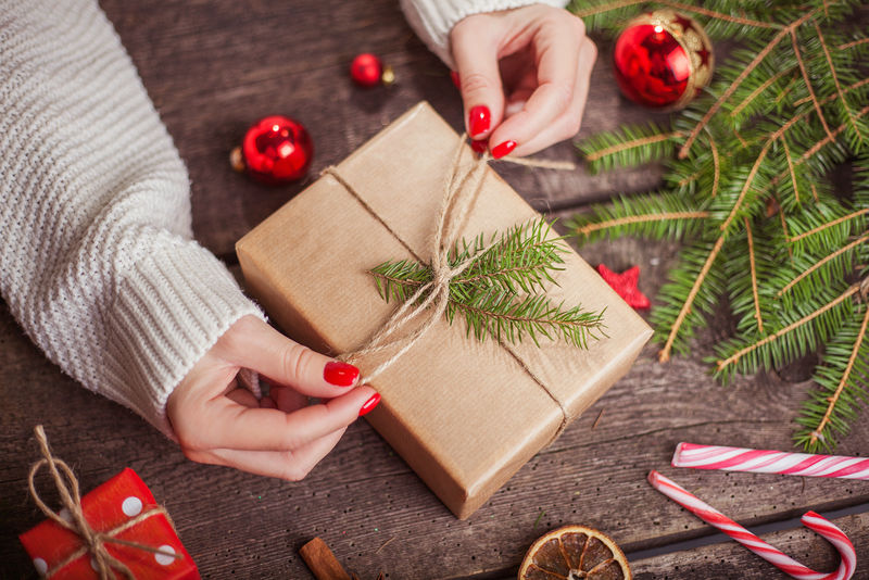 假日装饰概念-女人的手用手工纸和丝带系着圣诞假期礼物-在圣诞礼品盒做蝴蝶结-创造***好-圣诞礼物包装平铺