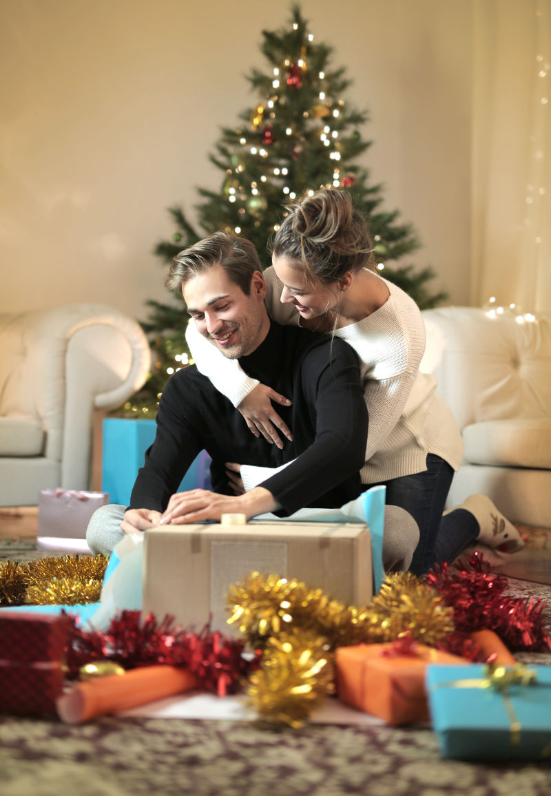 一对甜蜜的夫妇正在享受他们的圣诞假期-包装礼物
