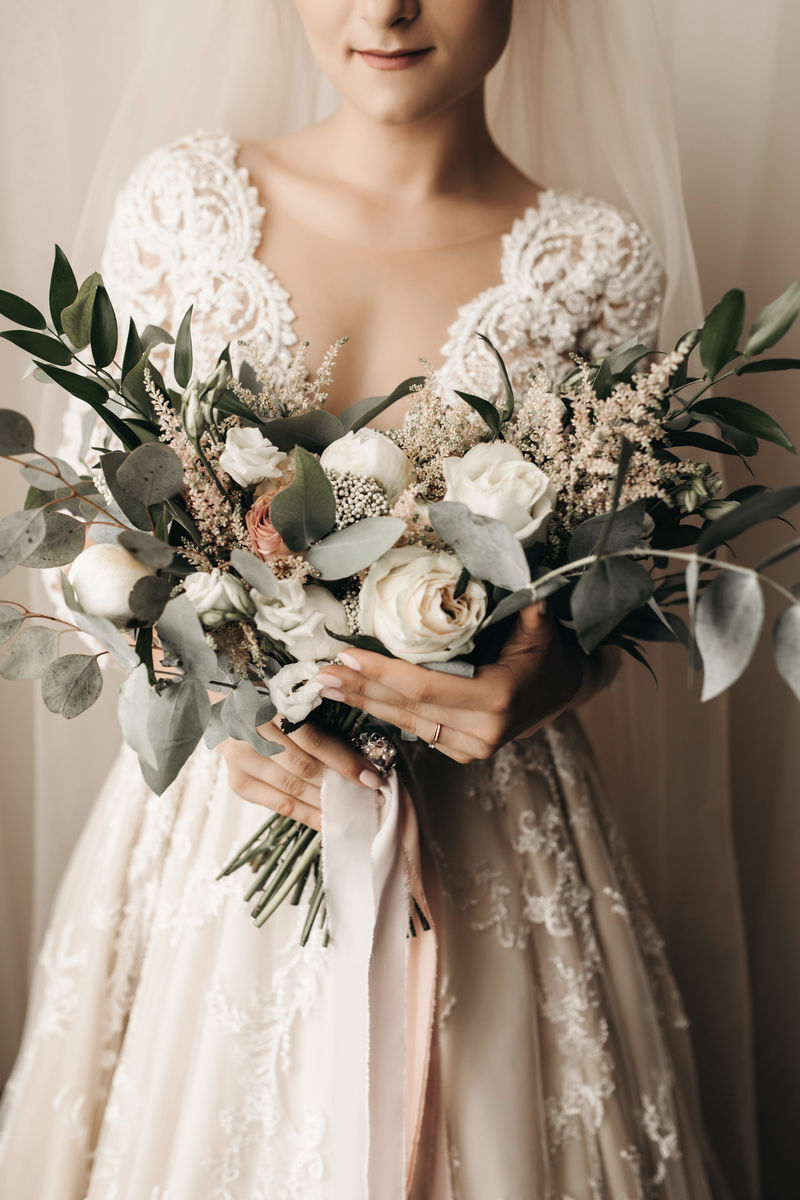新娘穿着漂亮的婚纱，带着漂亮的花束
