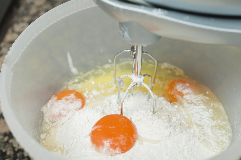 用搅拌机把鸡蛋、面粉和糖放在碗里搅拌。
