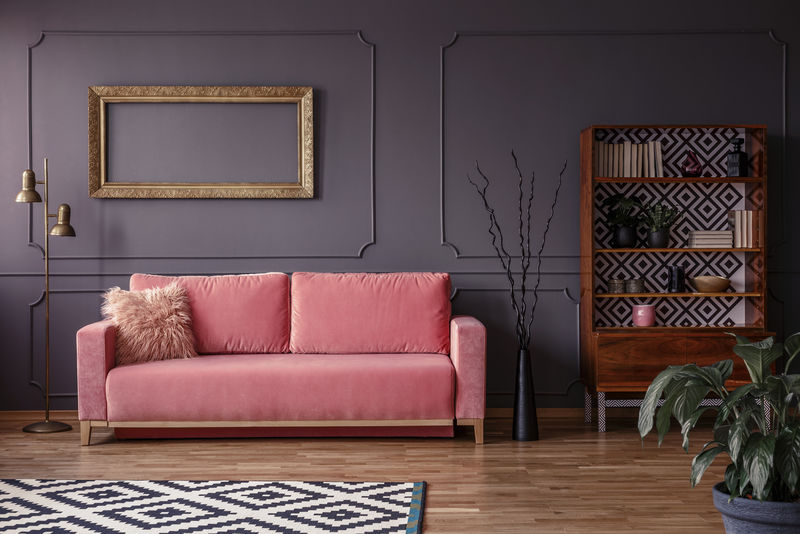 灰色墙壁上的粉色长椅，以埃莱加金色框架为模型