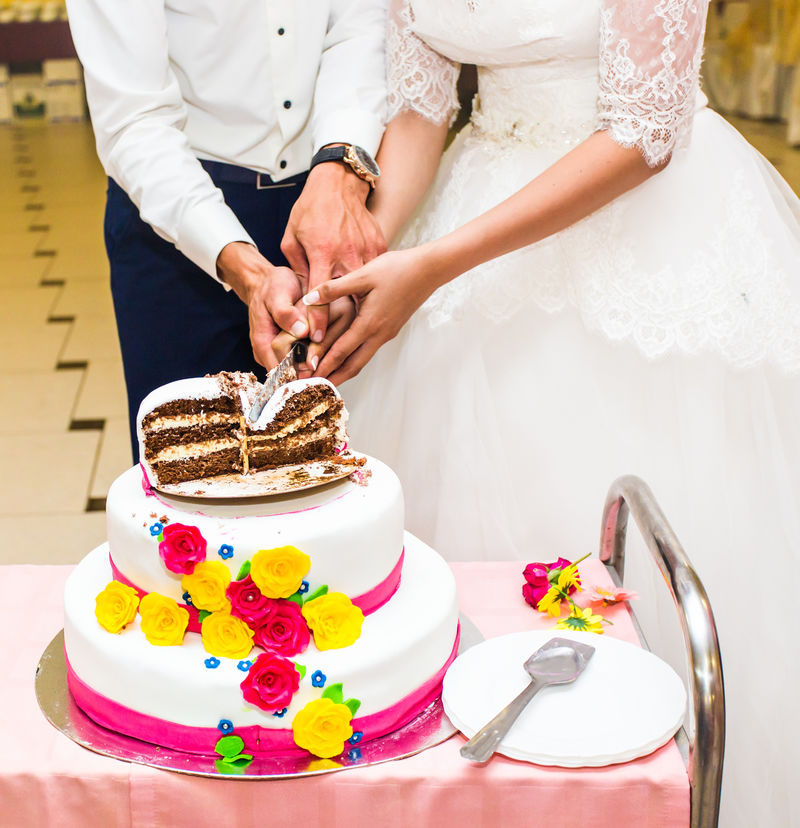 新娘和新郎正在切他们的结婚蛋糕