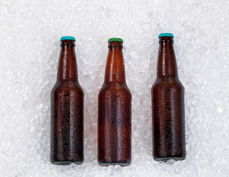 在一堆冰上冷藏的啤酒瓶