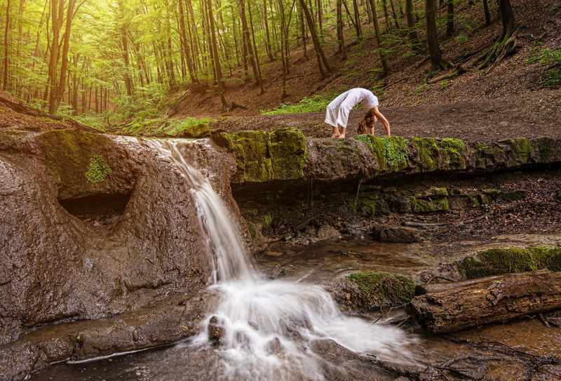 女人在大自然中练习瑜伽，瀑布。