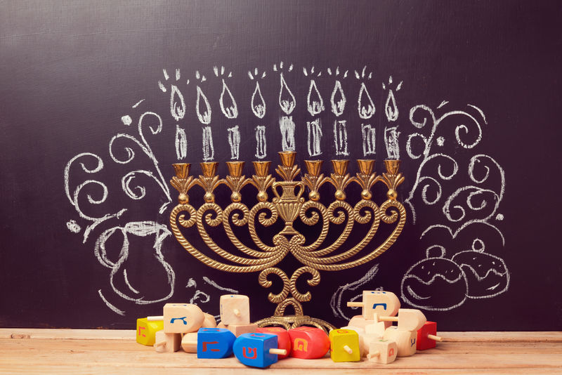 创造性的犹太节日光明节背景，带menorah，用手绘在黑板上旋转顶部