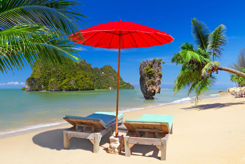 泰国的热带海滩风光，带阳伞和躺椅