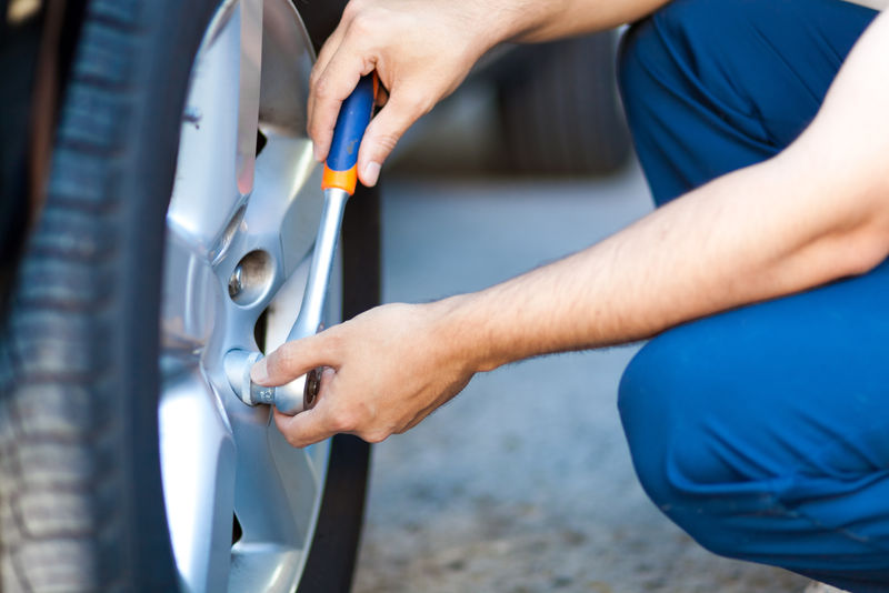 汽车修理工在车间里更换轮胎或轮辋