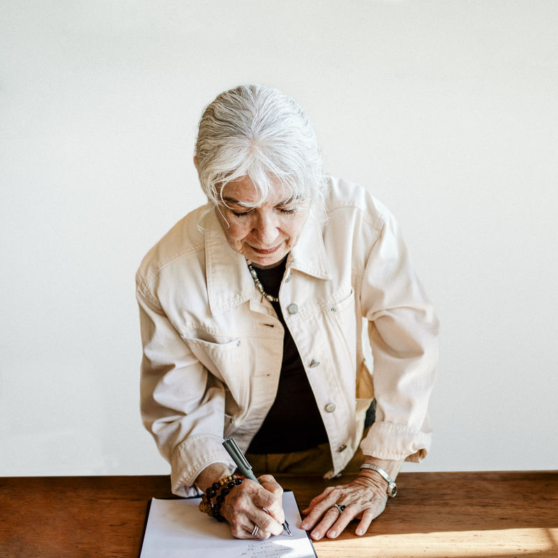 在纸上签名的老妇人