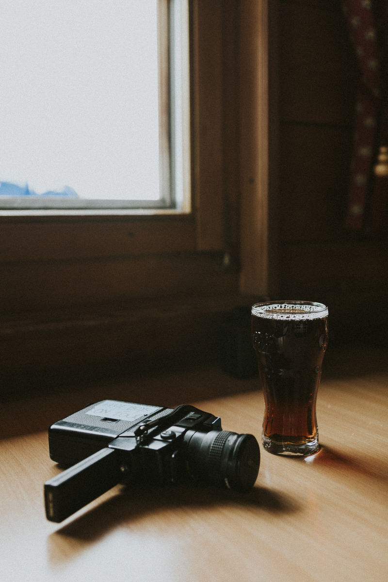 老式的电影摄影机和一杯干啤酒
