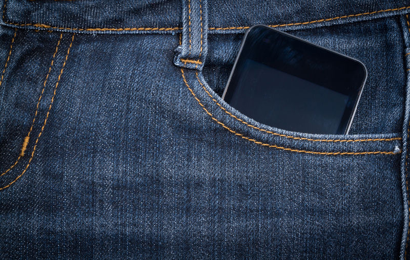 黑色智能手机在你的口袋牛仔裤背景