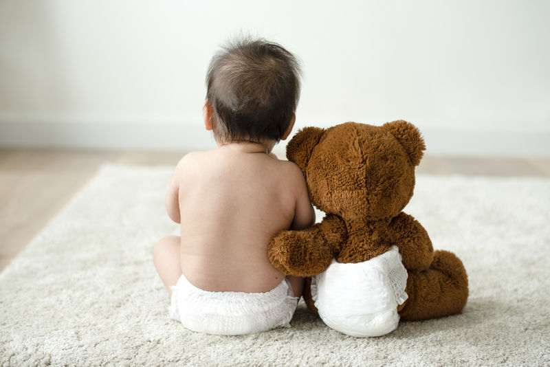 一个带着泰迪熊的婴儿的后背