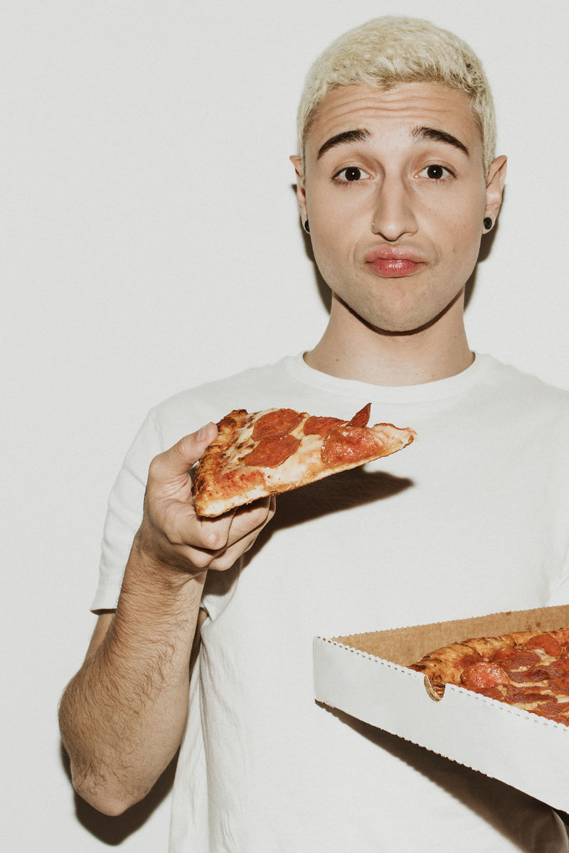 吃意大利香肠披萨的男人