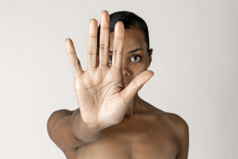 赤膊的黑人妇女在做停止手势