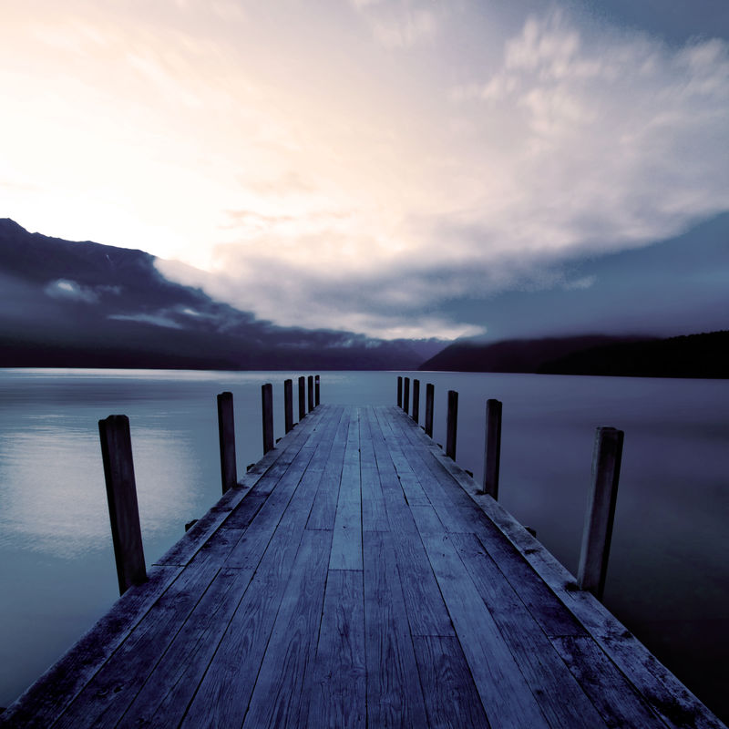 新西兰日出时的码头和平静的湖面