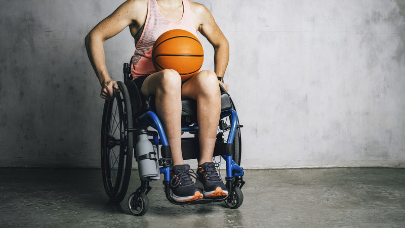 坐在轮椅上打篮球的女运动员