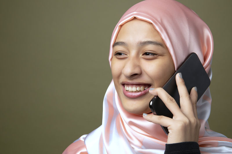 一位穆斯林妇女使用手机的画像