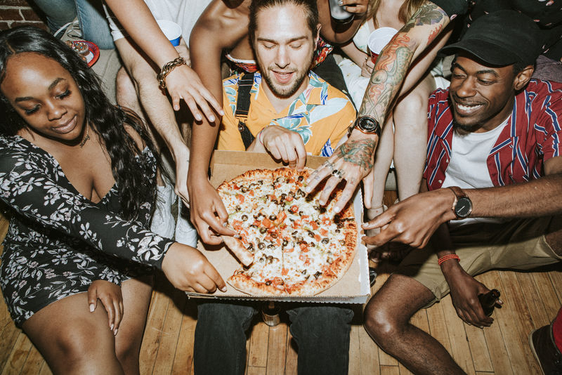 一群在聚会上享用披萨的朋友