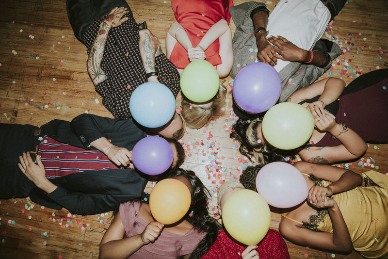 朋友们带着气球在聚会上躺在地板上