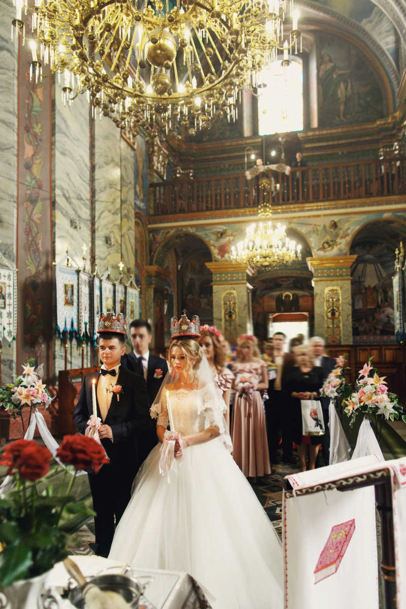 在教堂的皇冠上的宗教金发新娘和英俊新郎