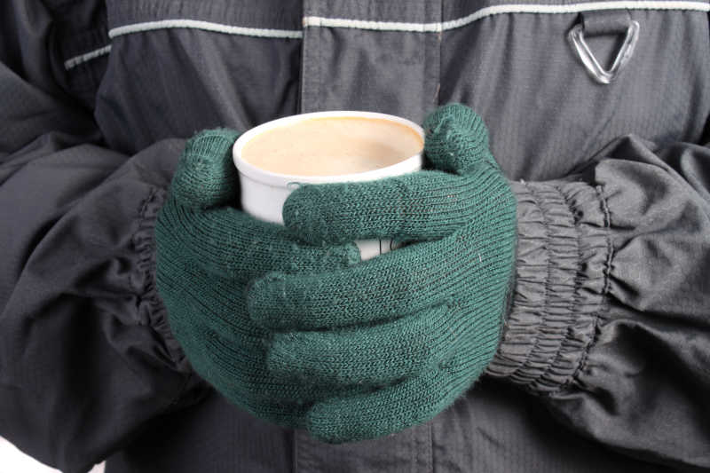 抱着咖啡杯取暖的人