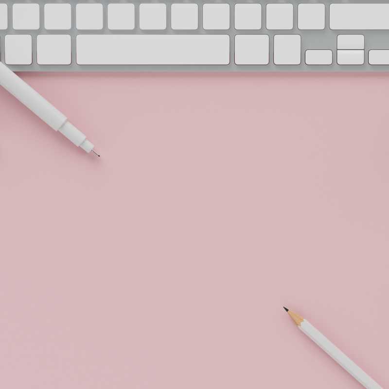 白铅笔和电脑上的粉红色粉彩背景复制空间