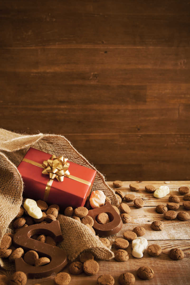 木桌上精美的礼物盒和巧克力字母糖果