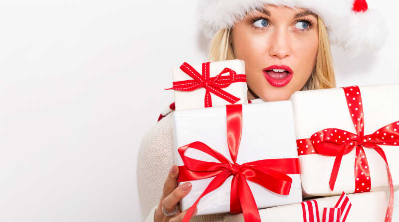 白色背景下的美女抱着的圣诞礼物盒