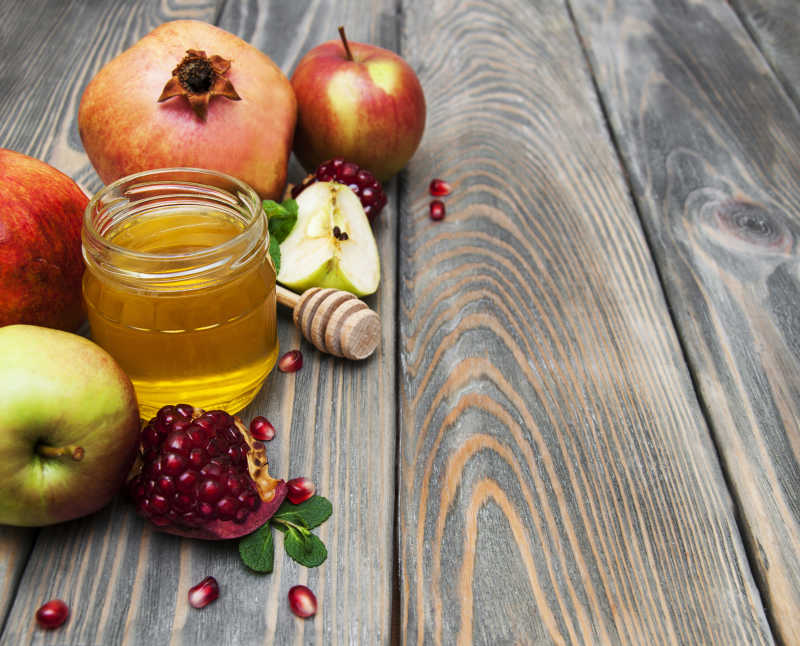 木桌背景下的新鲜水果和蜂蜜