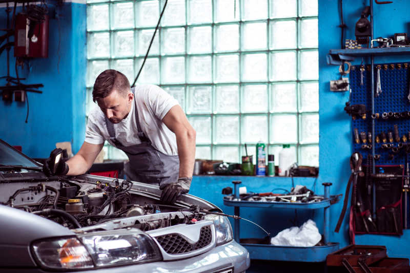 汽车修理厂里正在检修汽车的汽车修理工