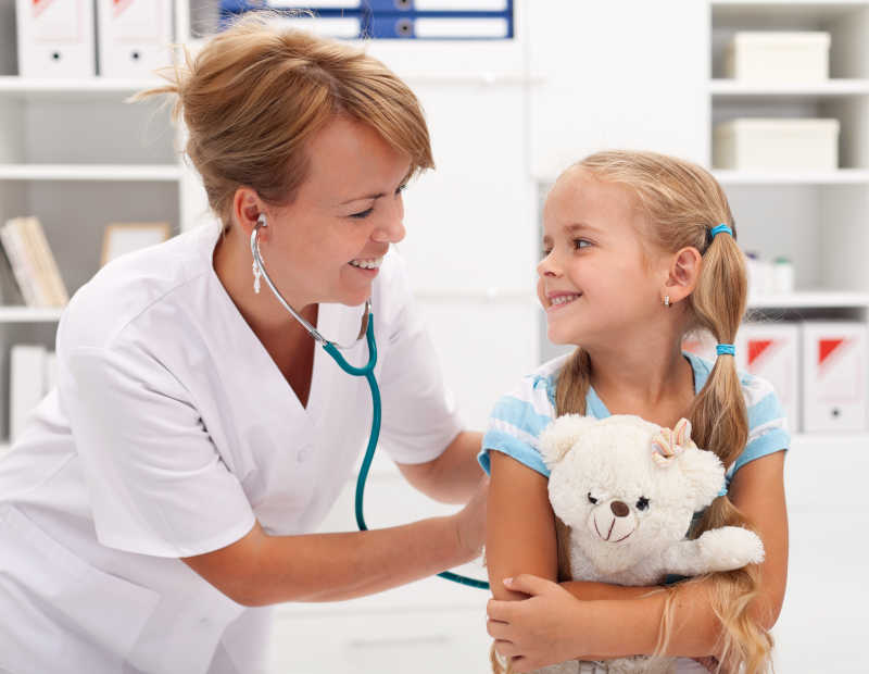 快乐的小女孩接受医生用听诊器检查