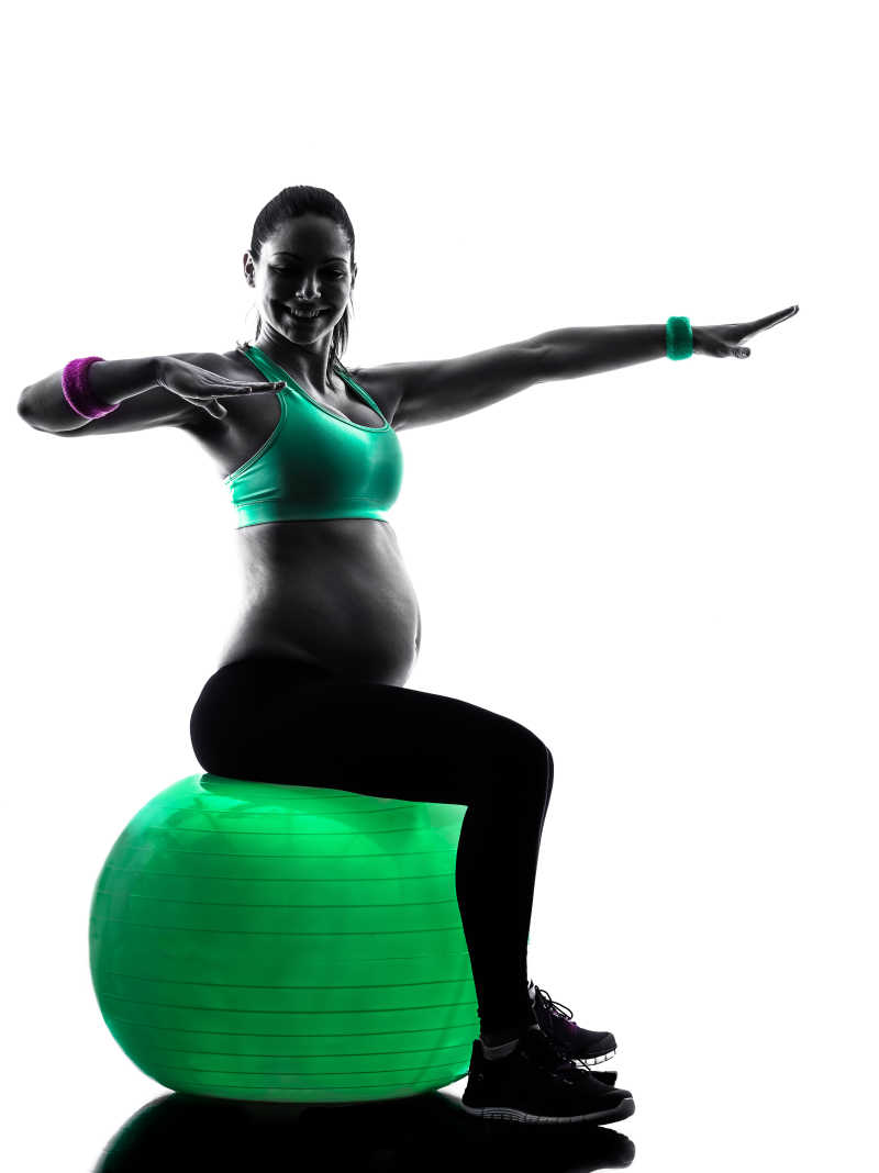 坐在瑜伽球上健身锻炼的孕妇