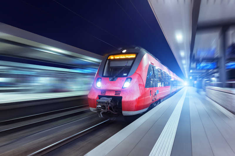 现代高速红色旅客列车夜间路过火车站