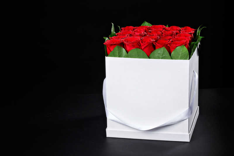 黑色背景下的一盒红色玫瑰花