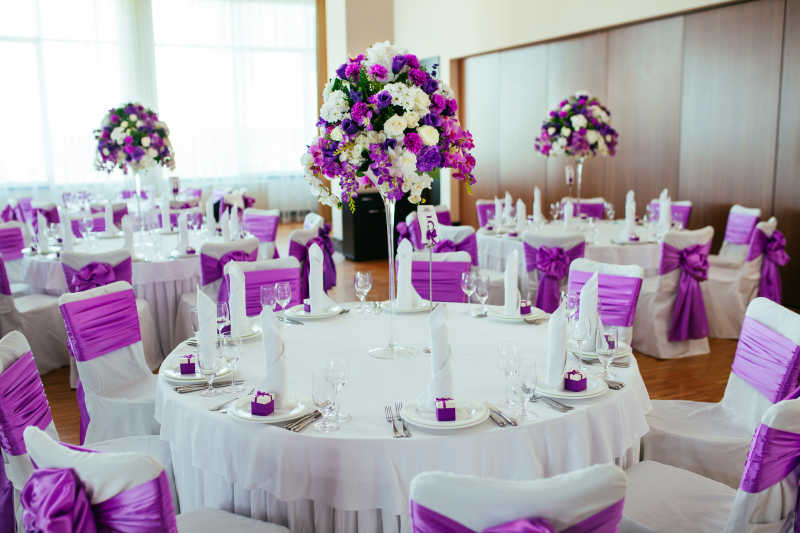 结婚婚礼餐桌上的紫色花朵装饰和白色餐巾装饰