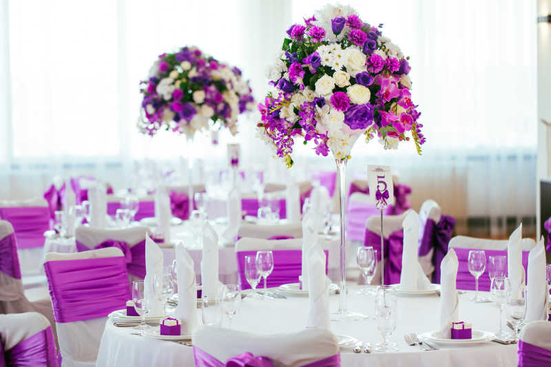 结婚婚礼餐桌上的紫色玫瑰花和餐盘餐巾装饰