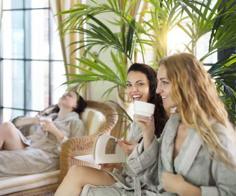三位年轻快乐的女性在温泉度假村喝茶