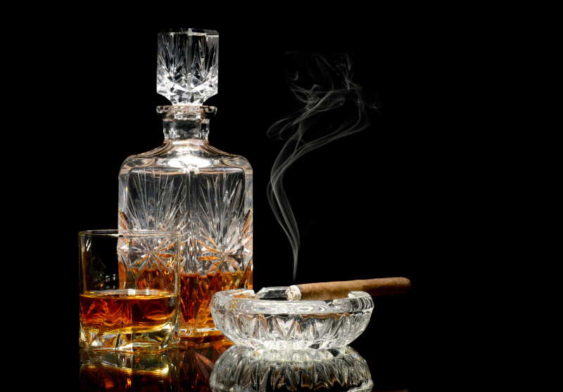 黑背景的威士忌和雪茄桌上的雪茄