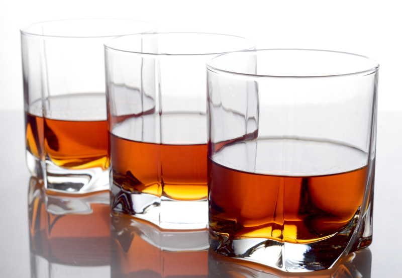 白背景上的排列整齐的三杯威士忌