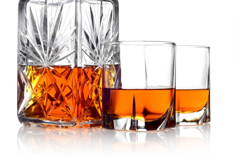 威士忌装在玻璃瓶里和两个杯子中