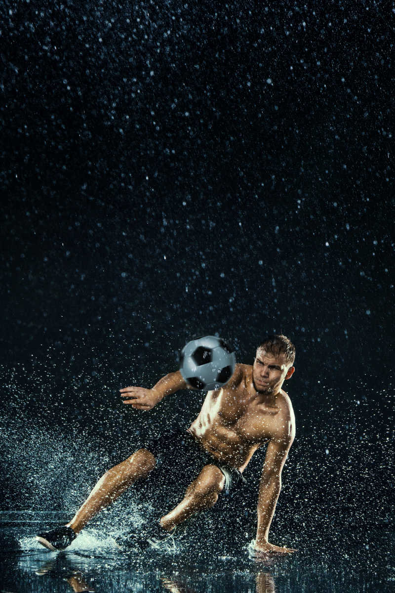 黑色背景下足球运动员在水下的水滴