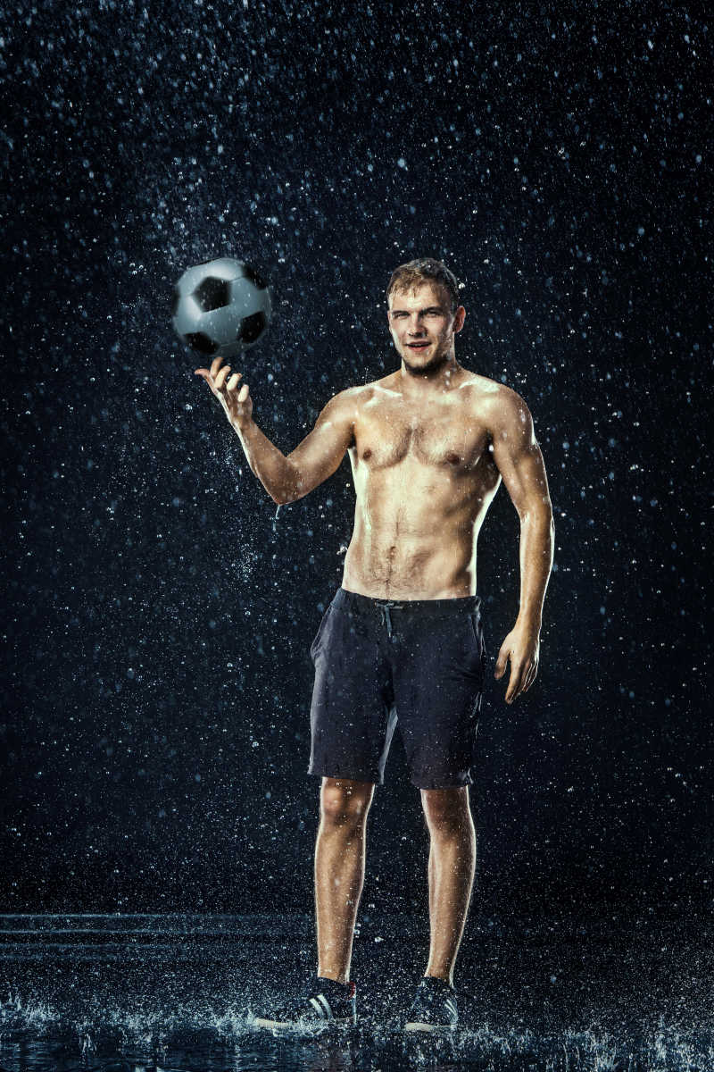 水滴在足球运动员附近的黑色背景下