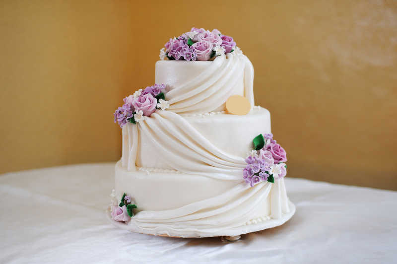 用紫色花朵装饰的婚礼蛋糕