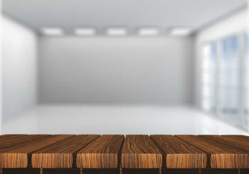 白色的空白房间里的原色木桌