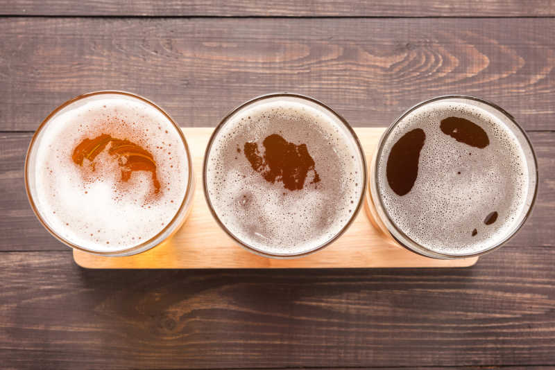 桌子上三杯不同品质的啤酒