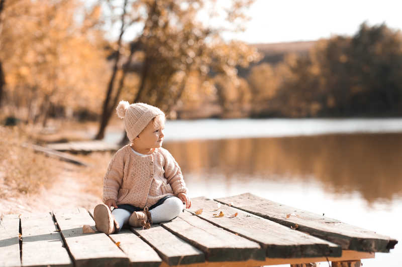 穿着针织秋装坐在公园里的女婴