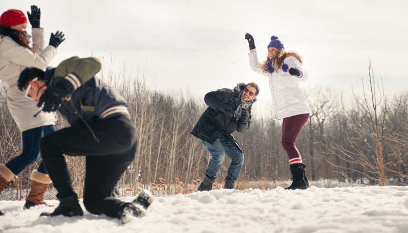 年轻朋友在雪地上的扔雪球