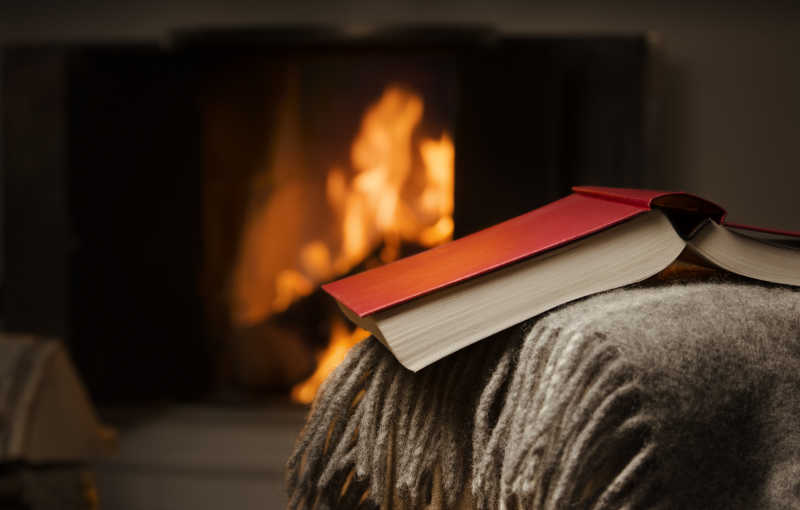 壁炉前打开的书和平而温暖的形象