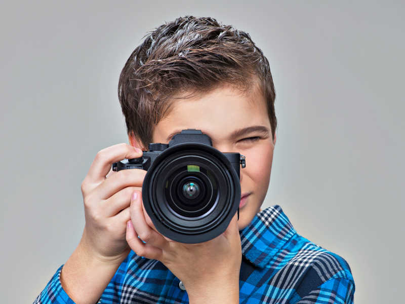 青少年男孩用数码单反相机拍照