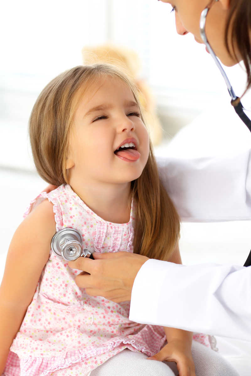 医生用听诊器检查一个可爱的小女孩