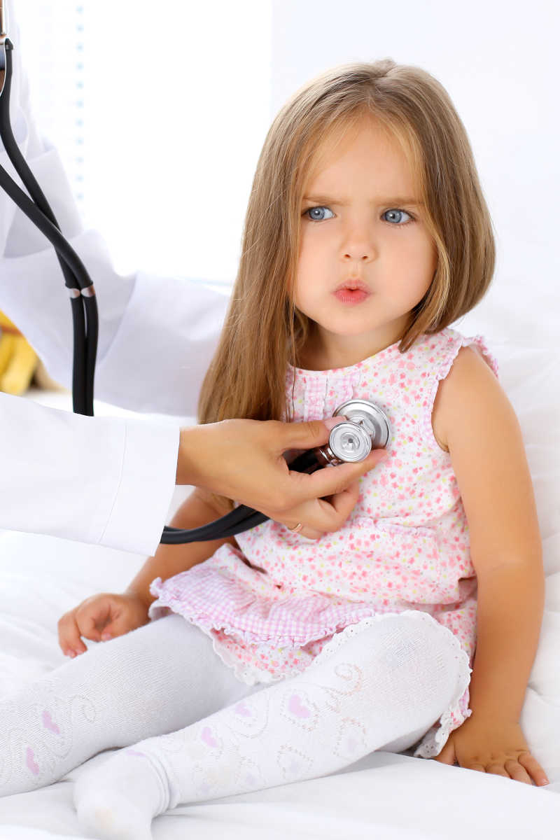 医生用听诊器检查一个生病的小女孩